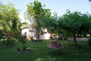 a garden with a table with flowers in the grass at Ai Cipressi in Salemi