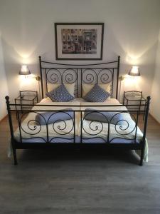 a bedroom with a black bed with two lamps at Al Boccalino Bed&Breakfast in Melide