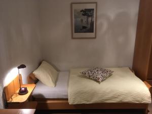 una piccola camera da letto con un letto con un cuscino sopra di Al Boccalino Bed&Breakfast a Melide