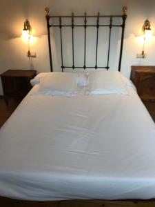a white bed with two pillows on top of it at La Casa Del Reloj in Molinaseca
