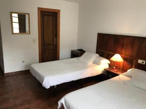 a hotel room with two beds and two lamps at La Casa Del Reloj in Molinaseca