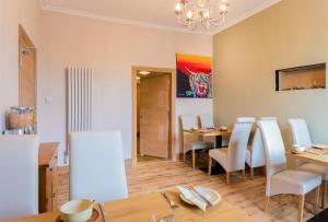 a dining room with a table and white chairs at Lakeview Guest House in Stranraer