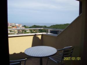 un tavolo e sedie su un balcone con vista di Family Hotel Saint George a Sinemorets