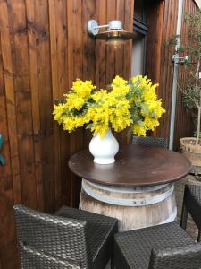 a table with a vase of yellow flowers on it at Les studios du Centre in La Teste-de-Buch