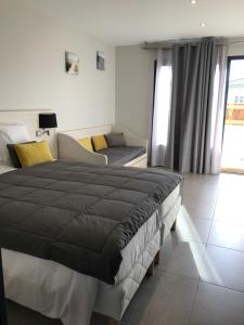 a bedroom with a large bed and a couch at Les studios du Centre in La Teste-de-Buch