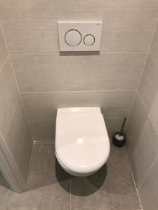 a toilet in a bathroom with a sign on the wall at Les studios du Centre in La Teste-de-Buch