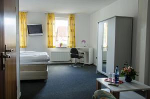 a hotel room with a bed and a desk at Hotel zum Rücking in Northeim