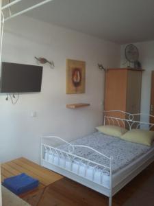 Schlafzimmer mit einem Bett und einem TV an der Wand in der Unterkunft Peter rooms in Ljubljana