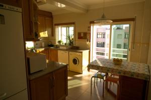 a kitchen with a sink and a counter with a table at Sun & Wave Apartment in Peniche