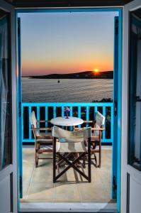 einen Tisch und Stühle auf einem Balkon mit Meerblick in der Unterkunft Hotel Livadia in Parikia