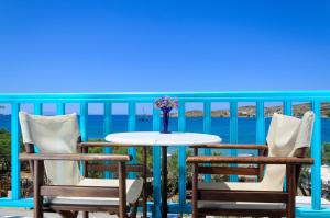 einen Tisch mit Stühlen und eine Vase mit Blumen auf dem Balkon in der Unterkunft Hotel Livadia in Parikia