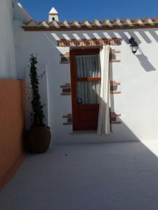 a door on a white building with a potted plant at Domo Baronia in Orosei