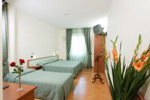 a hotel room with two beds and a television at Astor Hotel Vintage in Frosinone