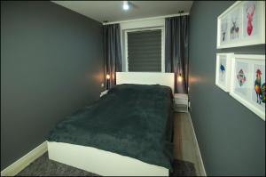 Un dormitorio con una cama y dos luces en la pared. en Apartamenty Łąkowa, en Białystok