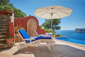 ポルト・ダンドラッチにあるLas Escaleras - Villa SIKA - 4Pのプールサイドの椅子とパラソル