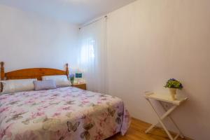 een slaapkamer met een bed en een nachtkastje met een tafel bij Plavi Apartman in Sukošan