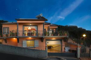 a large house with a balcony and a garage at Paradise House Calheta in Calheta