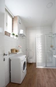 a white bathroom with a washing machine in it at Premium Class Apartments II in Zagreb