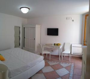 a bedroom with a bed and a table with chairs at camere di Palazzo Stapane in Santa Maria al Bagno