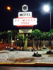 a motel with palm trees in front of a sign at Fort Myers Inn in Fort Myers