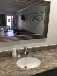 a bathroom sink in front of a mirror at Econo Lodge in Bakersfield