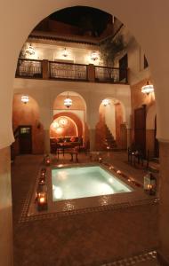 an indoor swimming pool in a building with an arch at Dar Warda in Marrakesh