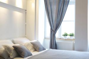 
a bed with a white comforter next to a window at Premium Class Apartments in Zagreb
