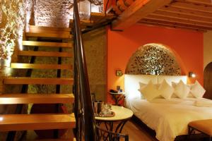 1 dormitorio con 1 cama y escalera en Casona de la Republica Hotel Boutique & SPA, en Querétaro