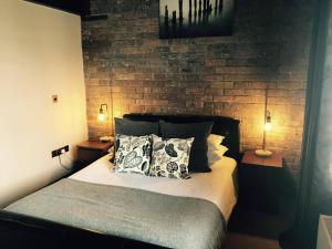 a bedroom with a bed with pillows and a brick wall at Ty Morgan's in Rhayader