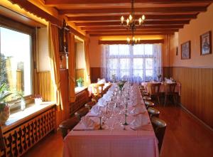 uma longa sala de jantar com uma longa mesa com copos de vinho em Logis Hotel Les Vosges em Dabo