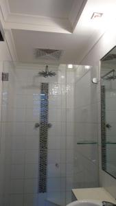 bagno con doccia in vetro e ventilatore a soffitto di Bali Studio a Darwin