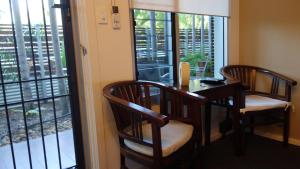 a room with two chairs and a table and windows at Bali Studio in Darwin