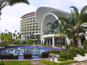 a hotel with a swimming pool in front of a building at Forest City Marina Hotel in Nusajaya