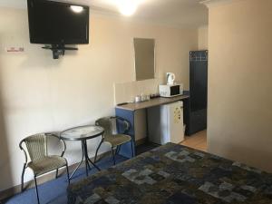 a hotel room with a television and a coffee table at Nanango Star Motel in Nanango