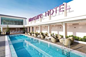 a hotel with a swimming pool in front of a hotel at Mercure Kuala Lumpur Shaw Parade in Kuala Lumpur