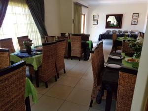 a dining room with tables and chairs in a restaurant at Ramandire B&B in eMalahleni
