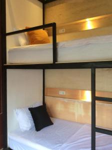 two bunk beds in a room with a white bed at The Patio Yogya in Yogyakarta