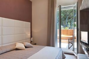 a bedroom with a bed and a balcony with a television at Hotel Belvedere in Milano Marittima +125 photos