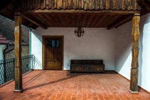 a porch with a bench on a brick floor at Casa Veche in Braşov