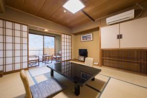 a room with a table and chairs in a room at Hotel Umenoyu in Matsumoto