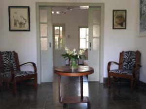 a room with two chairs and a table with a vase of flowers at The Patio Yogya in Yogyakarta +36 photos