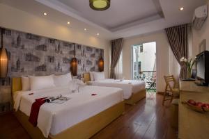 Giường trong phòng chung tại Hanoi Impressive Hotel