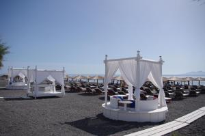 a group of lounge chairs and umbrellas on a beach at La Mer Deluxe Hotel & Spa in Kamari