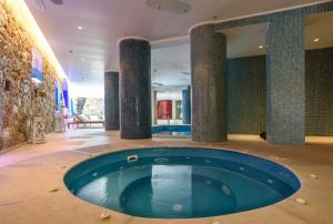 a pool in the middle of a room with columns at La Mer Deluxe Hotel & Spa in Kamari