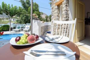 a wooden table with a plate of fruit on it at La Mer Deluxe Hotel & Spa in Kamari