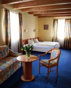 ein Hotelzimmer mit einem Bett, einem Tisch und einem Sofa in der Unterkunft Hotel-Cafe Rathaus in Bad Abbach
