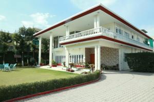 una grande casa bianca con balcone e cortile di Alaf Laila Guest House ad Abbottābād