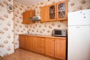 モスクワにあるInnDays on Belyaevo 24のキッチン(木製キャビネット、白い冷蔵庫付)