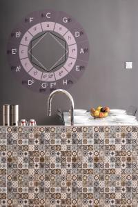 un bancone della cucina con lavandino e orologio sul muro di Elegant Apartment a Budapest