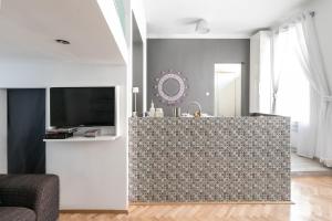 un soggiorno con cucina e parete piastrellata di Elegant Apartment a Budapest